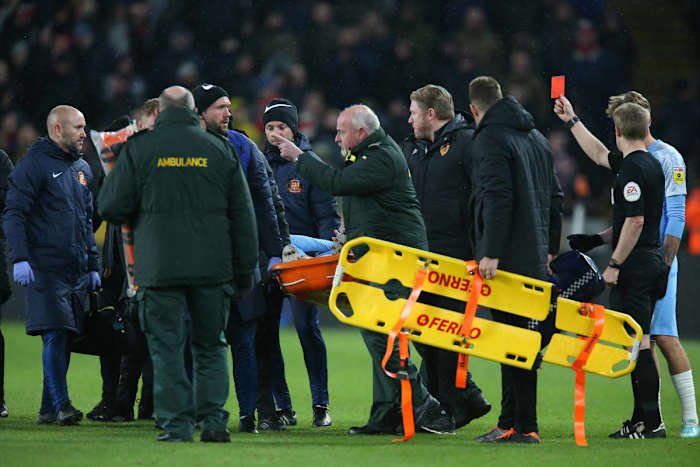 Embleton receiving his red card before being stretchered off. 